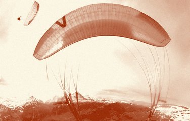 Paraglider wing overhead with a friend's wing in the distance.